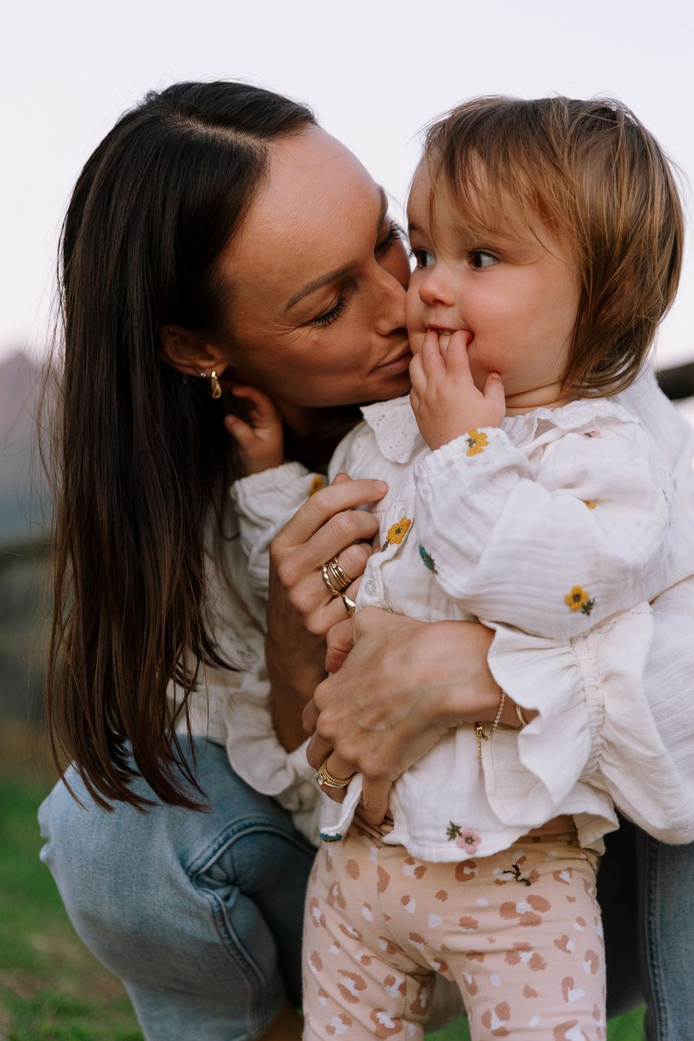 A tender moment of affection and connection shared between parent and child outdoors.