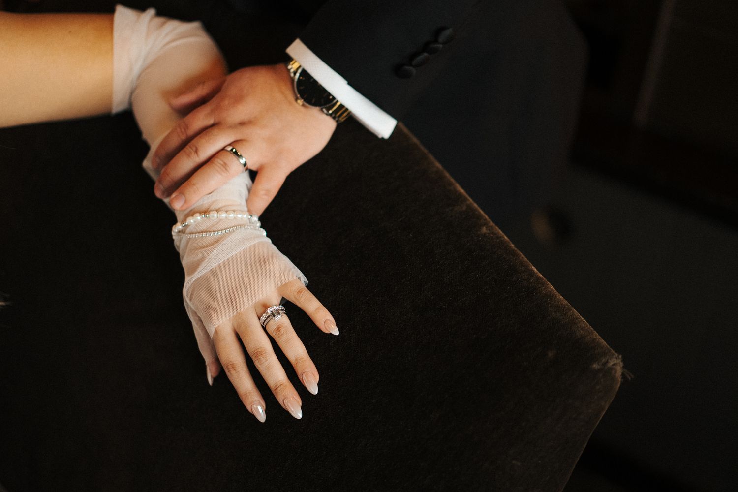 Close-up shot of hands holding a white chalk piece against a dark wooden background.