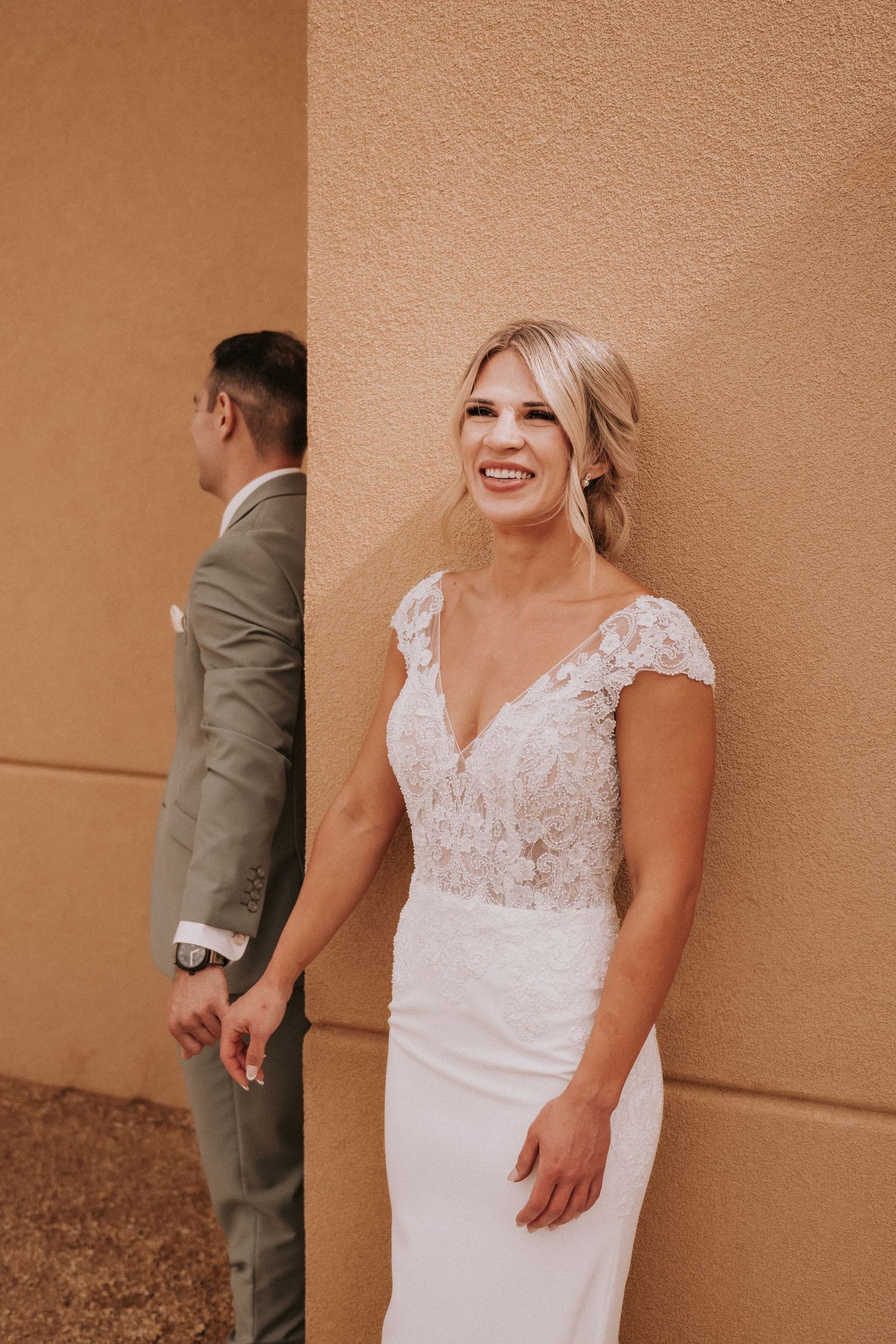 A collection of wedding photographs displaying a couple sharing romantic first look moments against a peach-colored wall. Santa Fe wedding