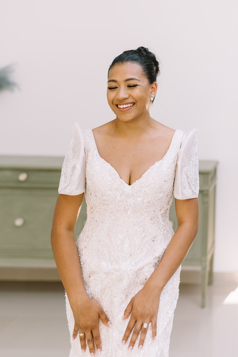 Four portrait shots showing a person wearing a white beaded wedding dress with short sleeves and a sweetheart neckline.