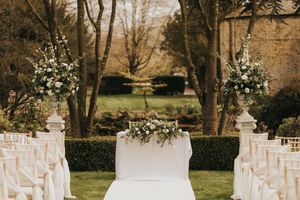 A rustic outdoor wedding ceremony setup with white garden chairs arranged in rows at Saltmarshe Hall - taken by Grimsby photographer.