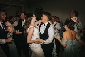 A couple shares a romantic dance moment at their wedding reception while guests celebrate at Saltmarshe Hall - taken by Grimsby photographer