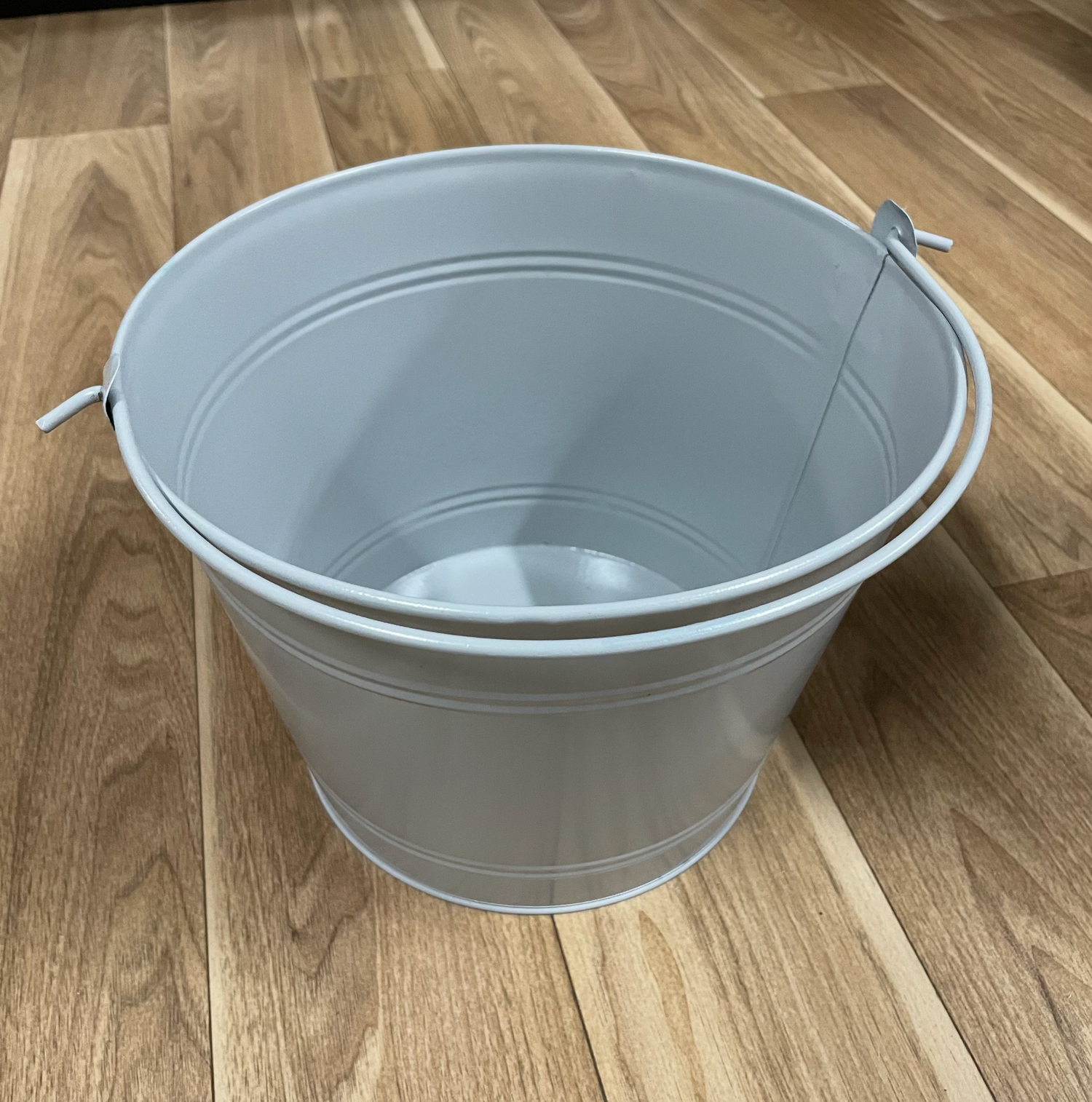 Gray plastic utility tub with handles shown from multiple angles on wooden floor.