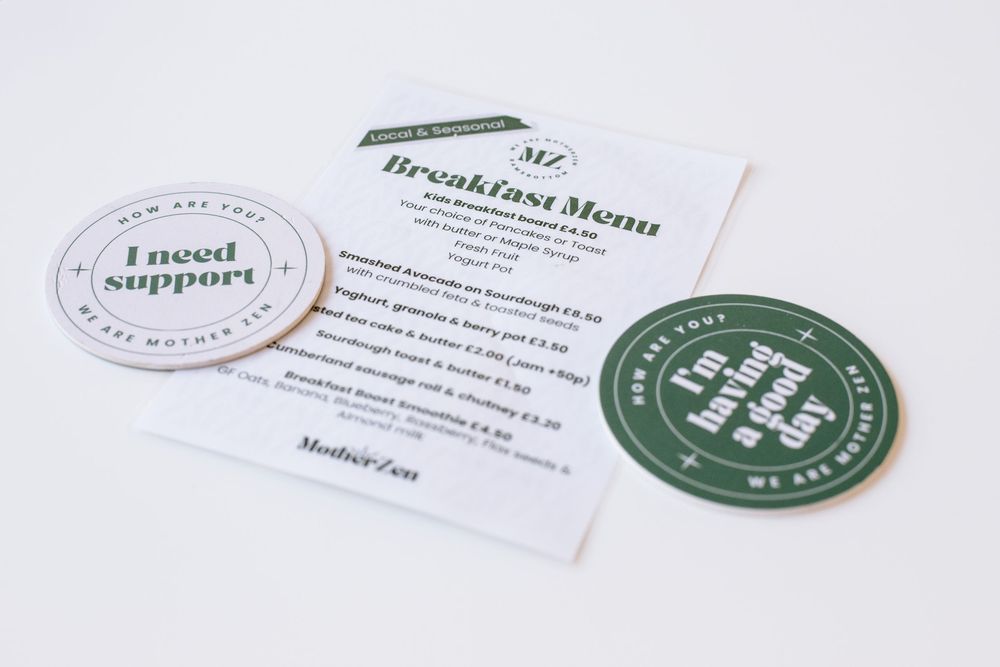 Custom branded business cards and menus with clean minimalist designs in green and white colors.