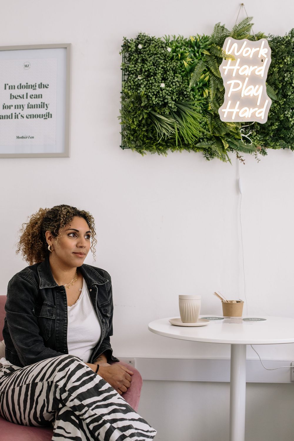 Minimal cafe interior with living wall art, white table and inspirational wall quote.