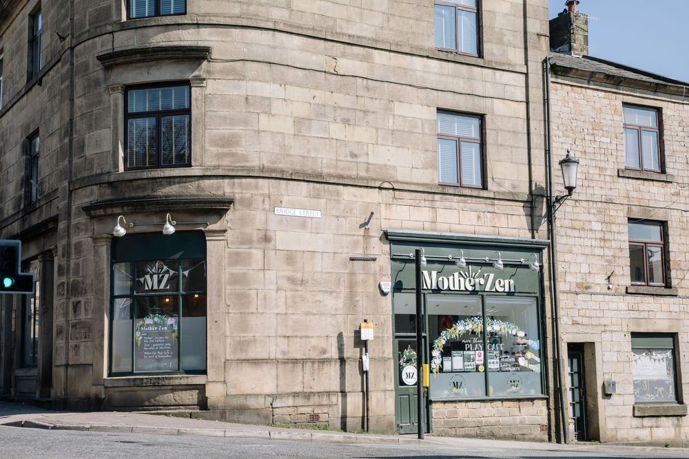Corner stone building with vintage architecture and shop windows on a quiet street.