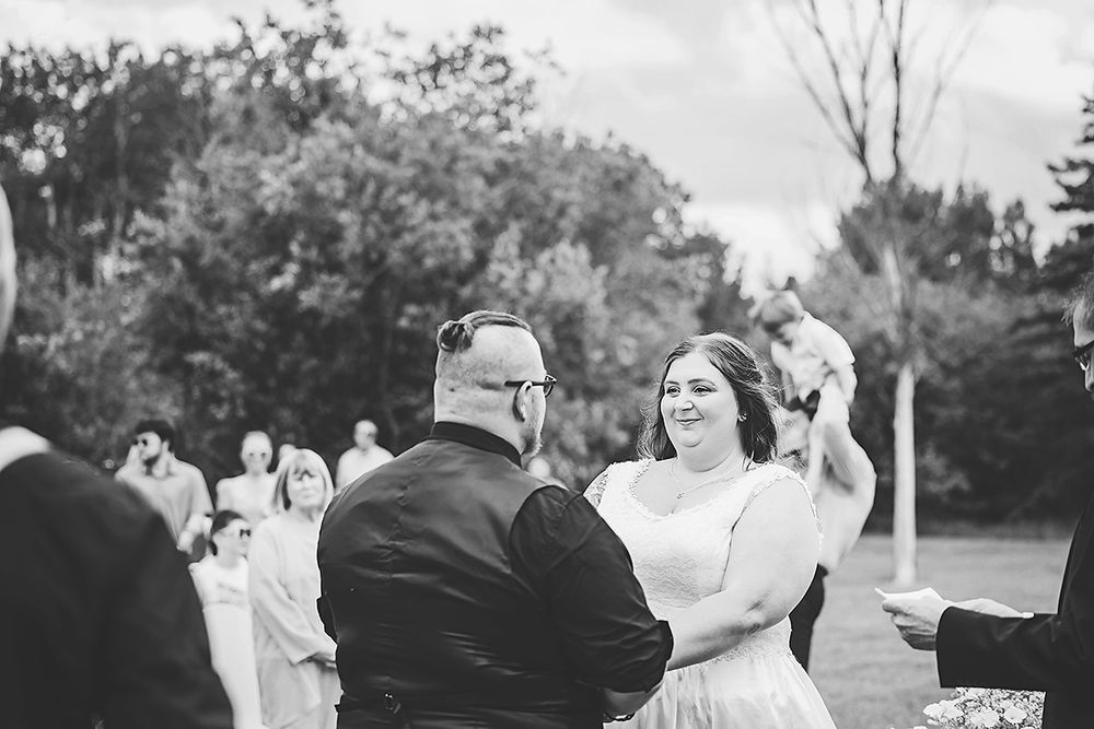 A wedding dance scene outdoors with guests looking on in the background.