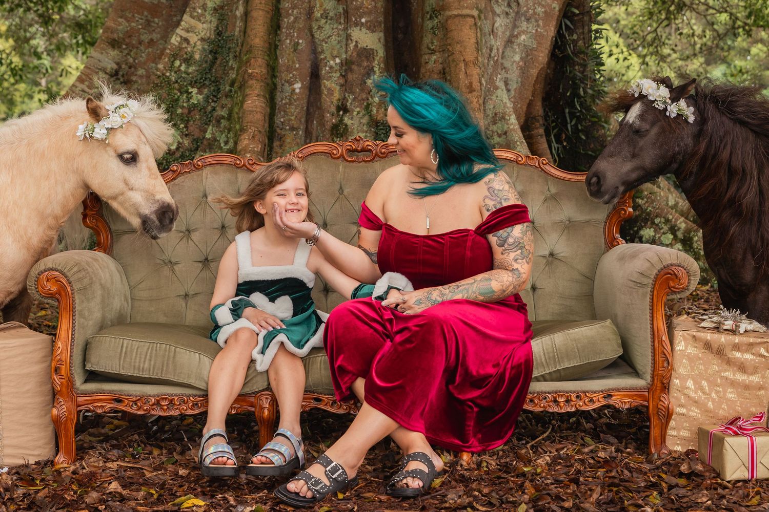 Family portrait session on a vintage tufted sofa outdoors with natural greenery backdrop.