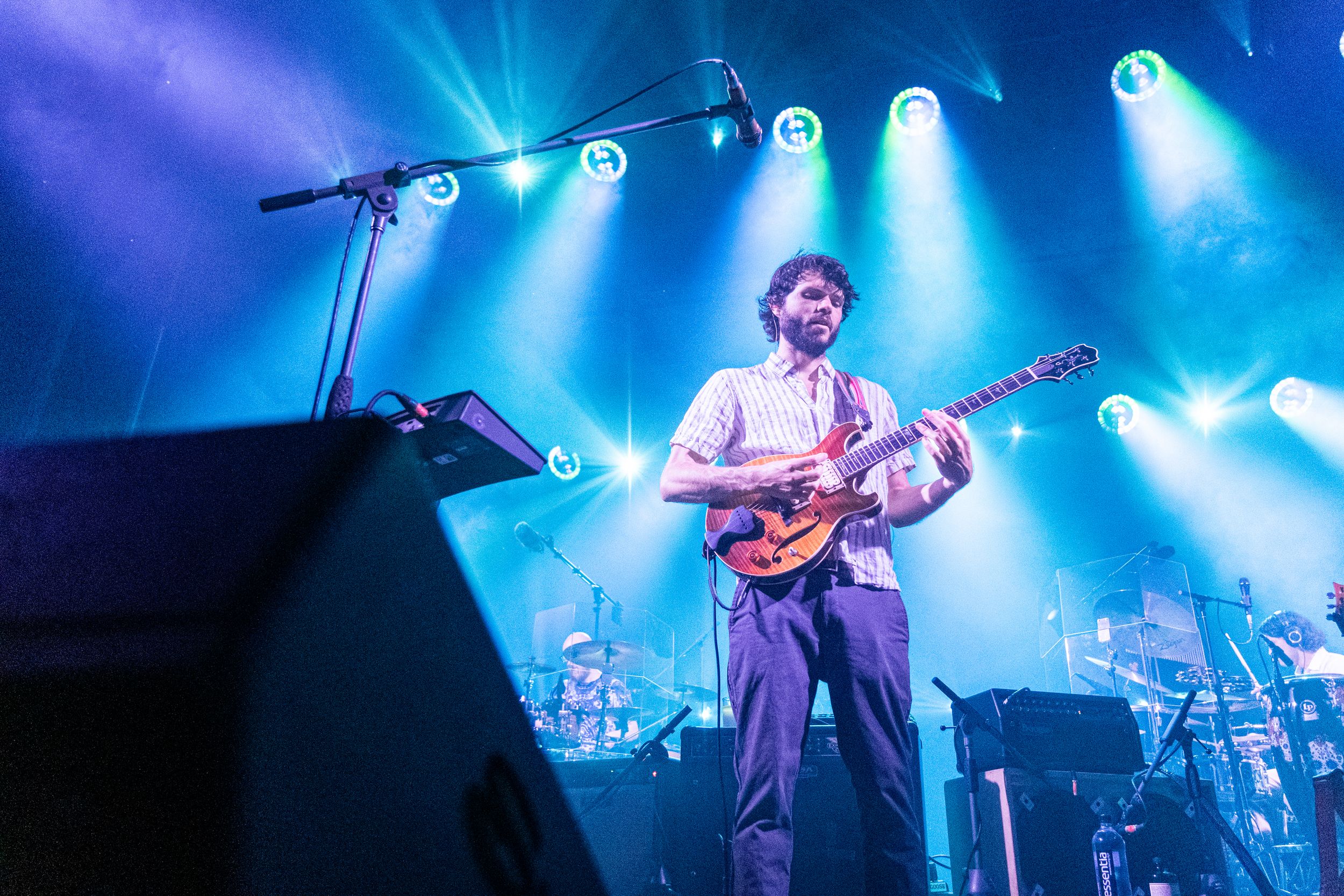 Musician playing guitar on a stage with lights