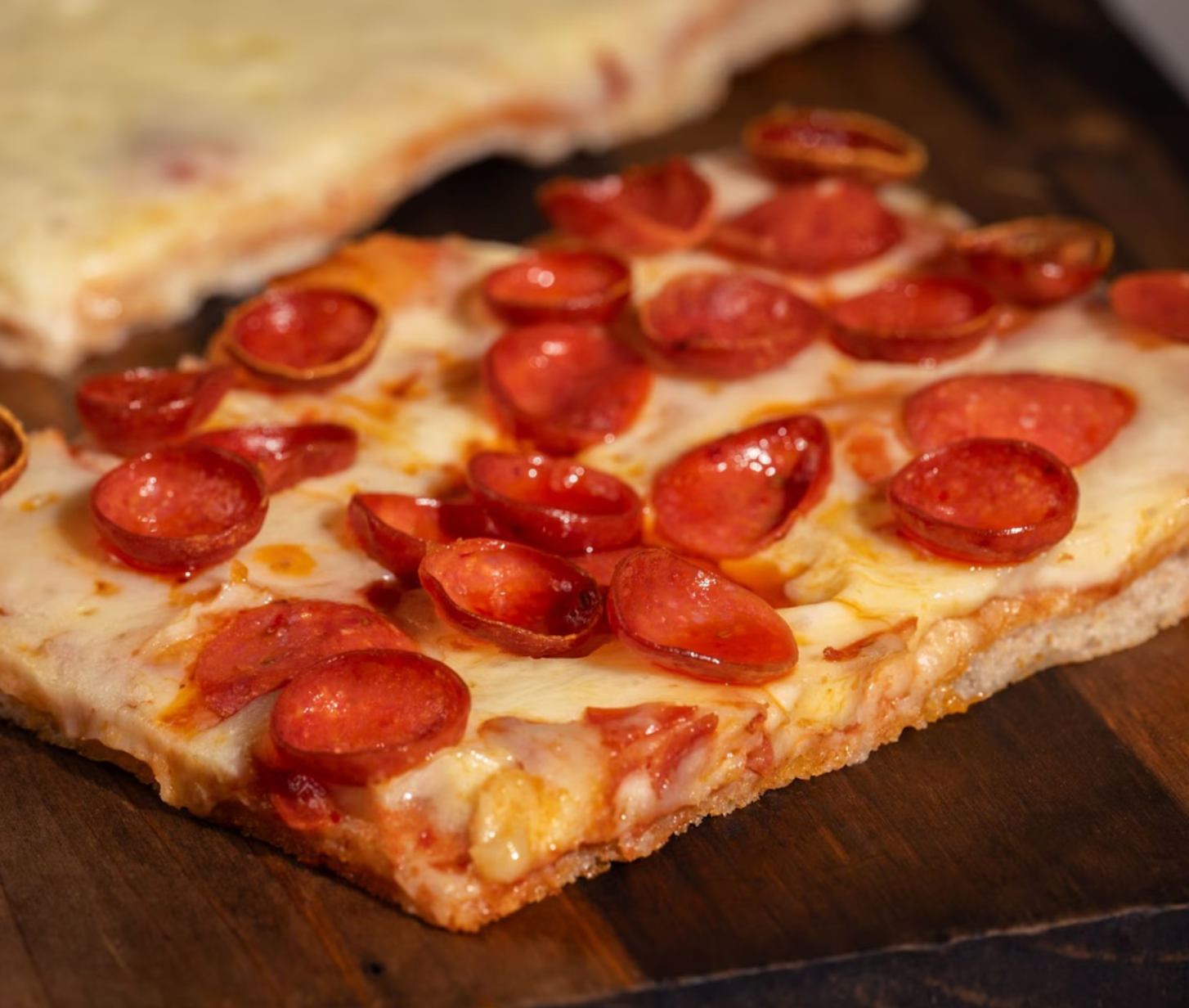 Close-up of pepperoni pizza with melted cheese on thin crust.