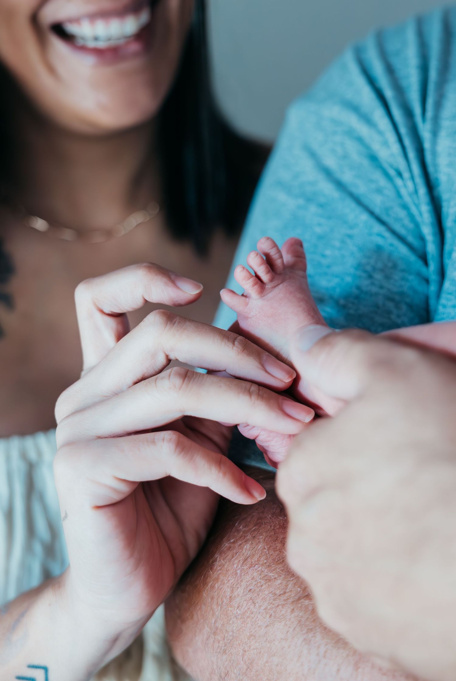 New family cuddling their newborn during in-home lifestyle session in Stuart Florida, newborn photographer in home session, treasure coast