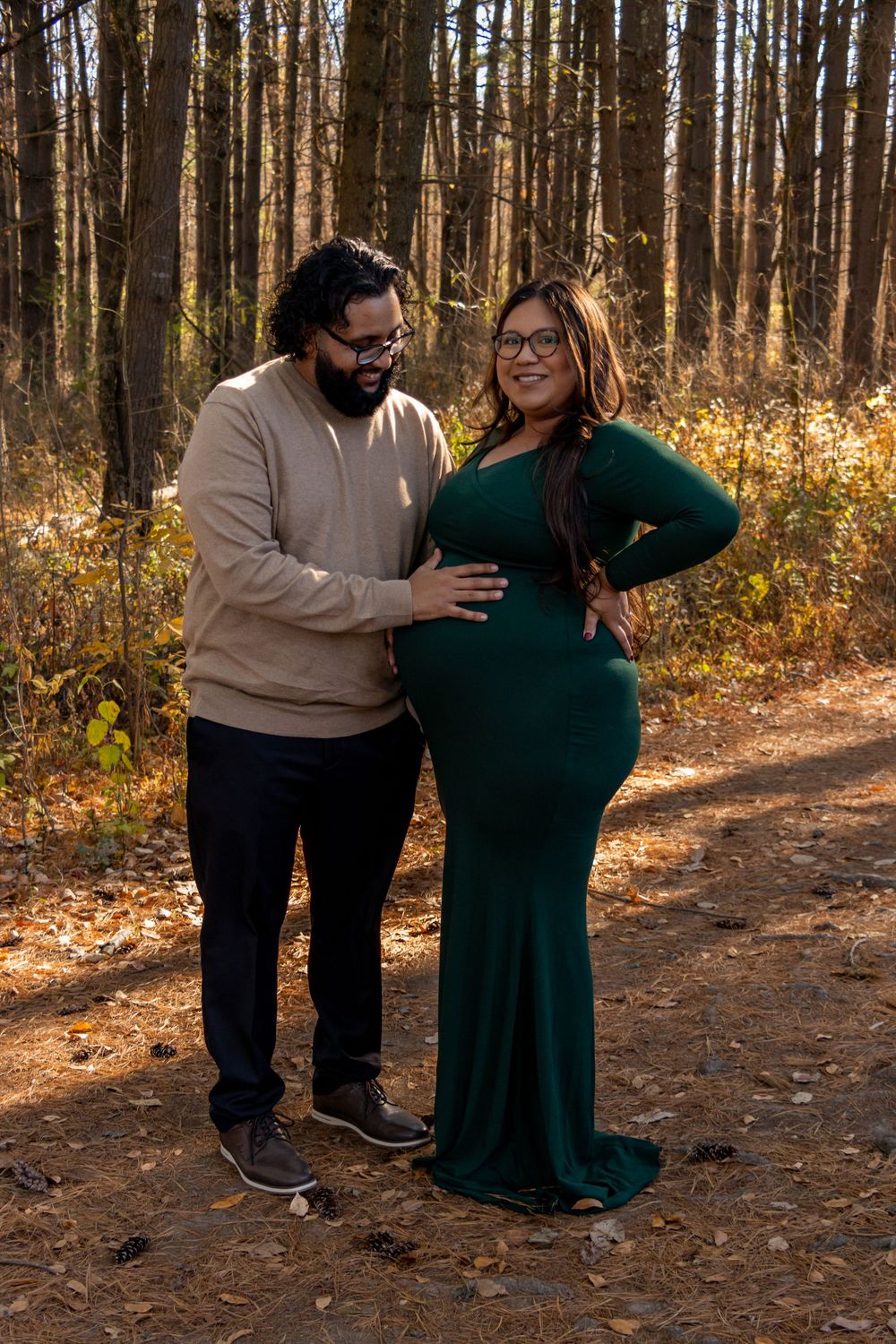 Couple sharing tender moments in wooded setting during autumn photo session.