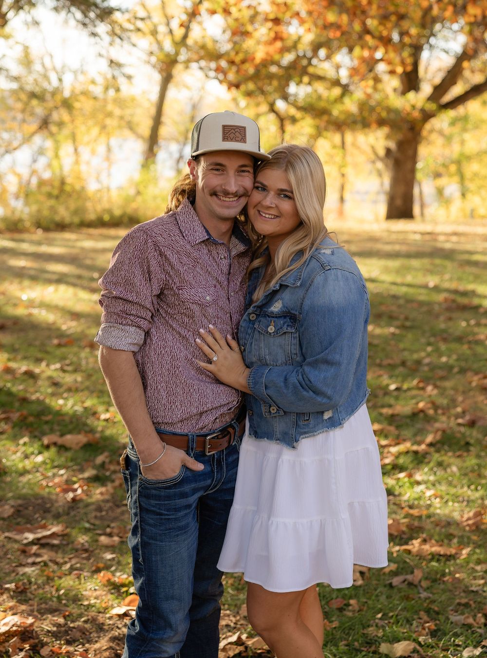 Casual couple photoshoot in rustic autumn setting with warm golden light.