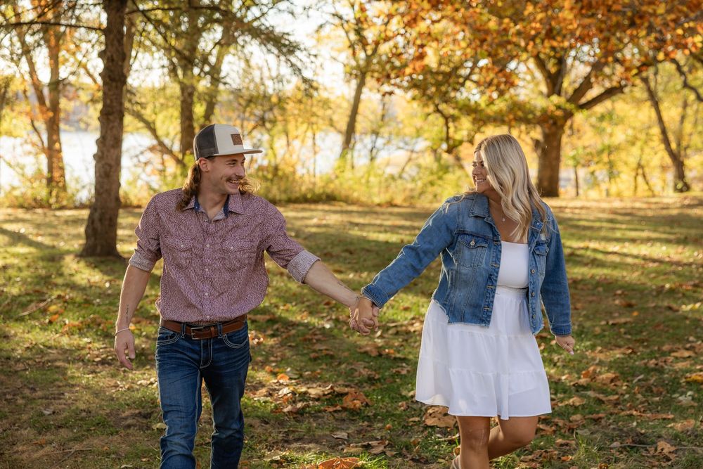 Couple shares intimate moment during fall photoshoot with golden leaves.