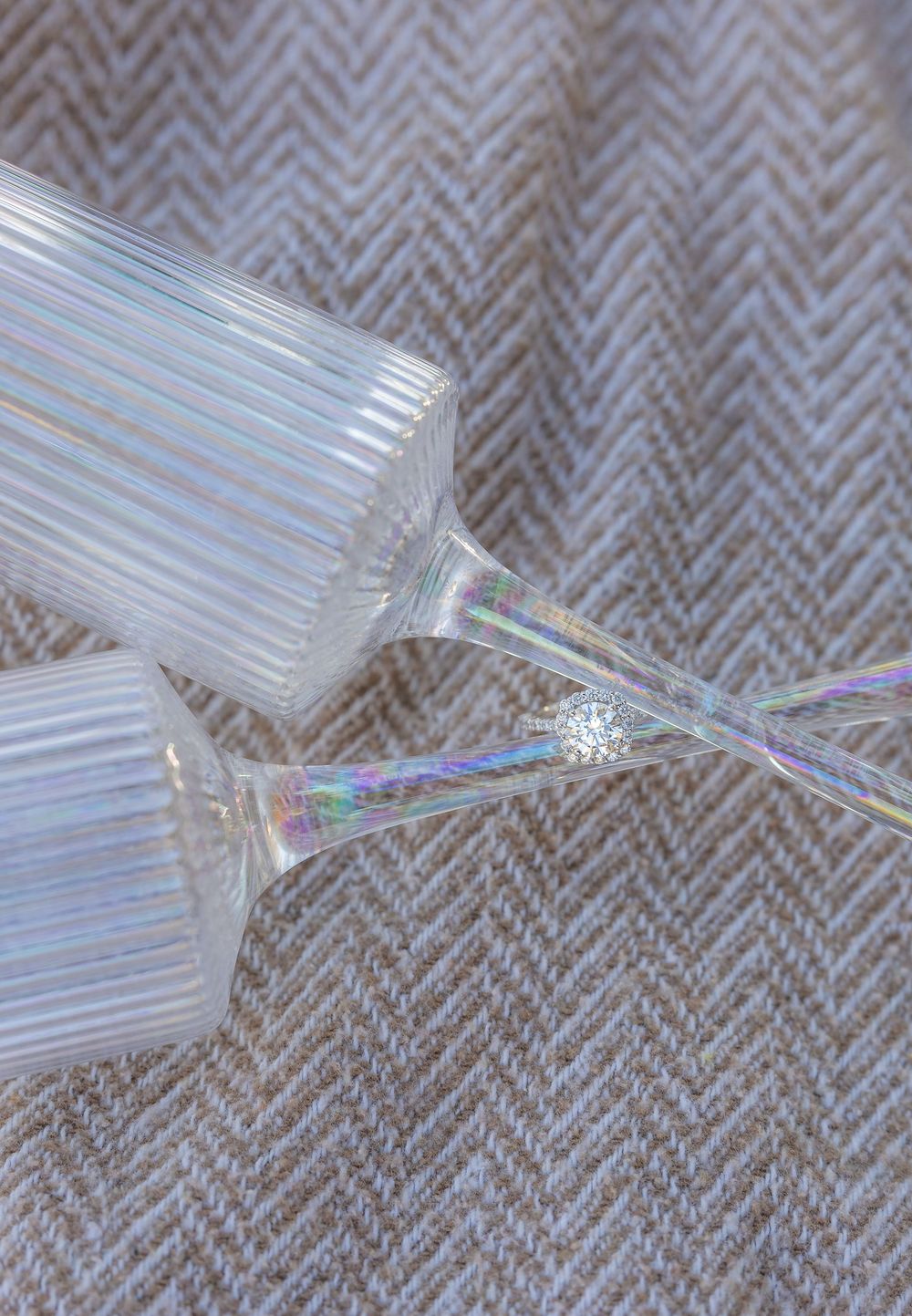 Close-up of broken glass fragments on a textured gray fabric.