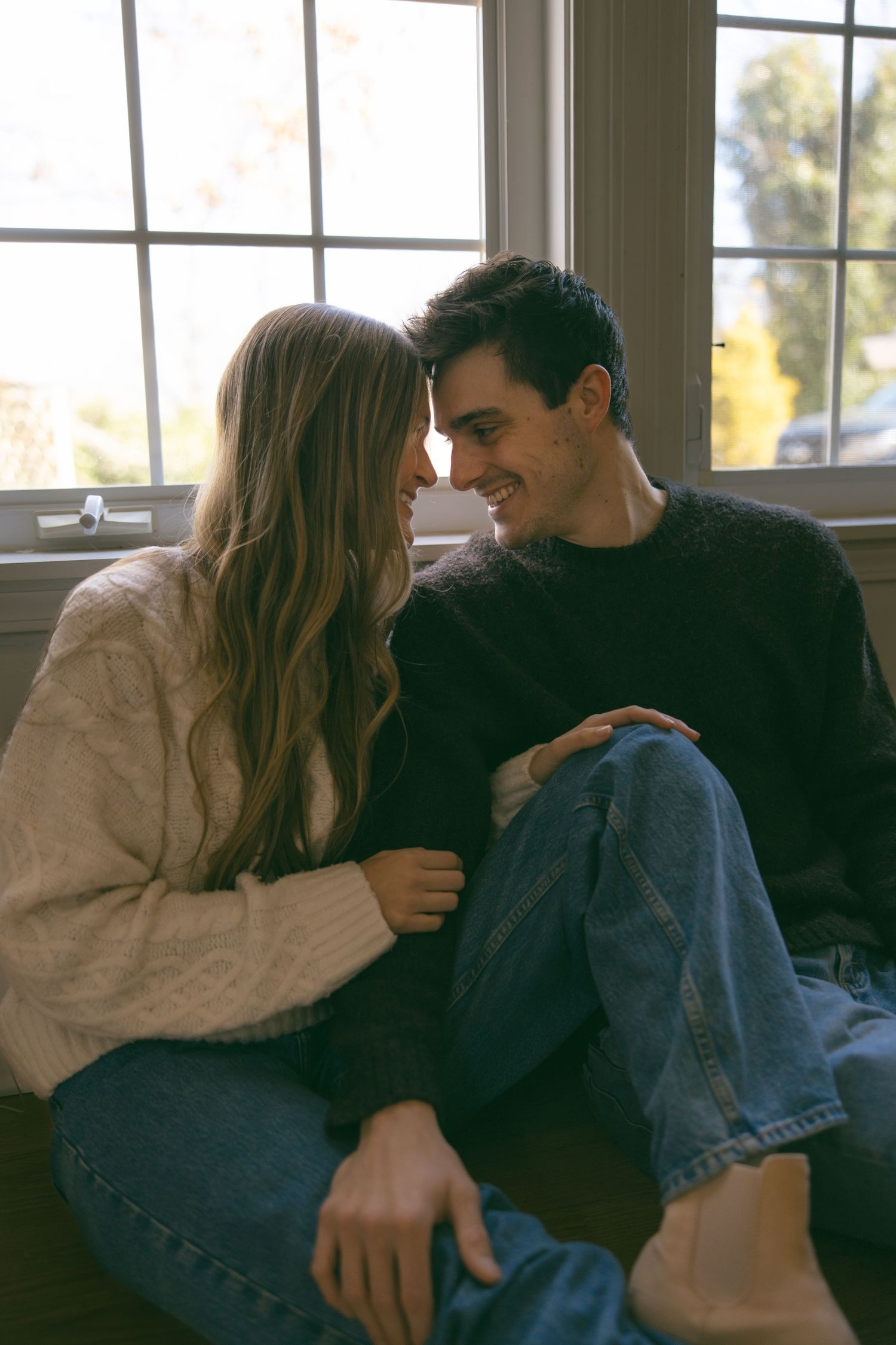 new home asheville photoshoot couples empty house lifestyle session window cuddling