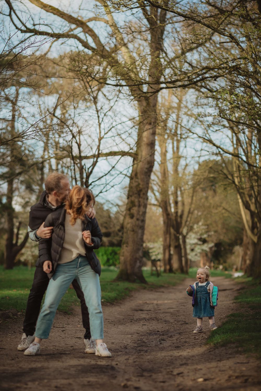 A playful sequence of interactions along a tree-lined path in a park.