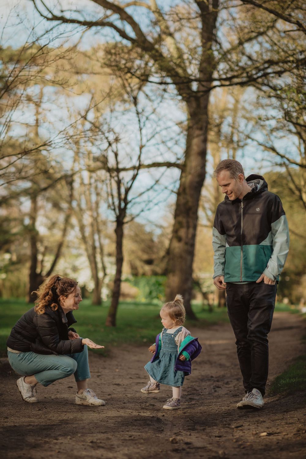 Family enjoying a walk together on a forest trail during golden hour.