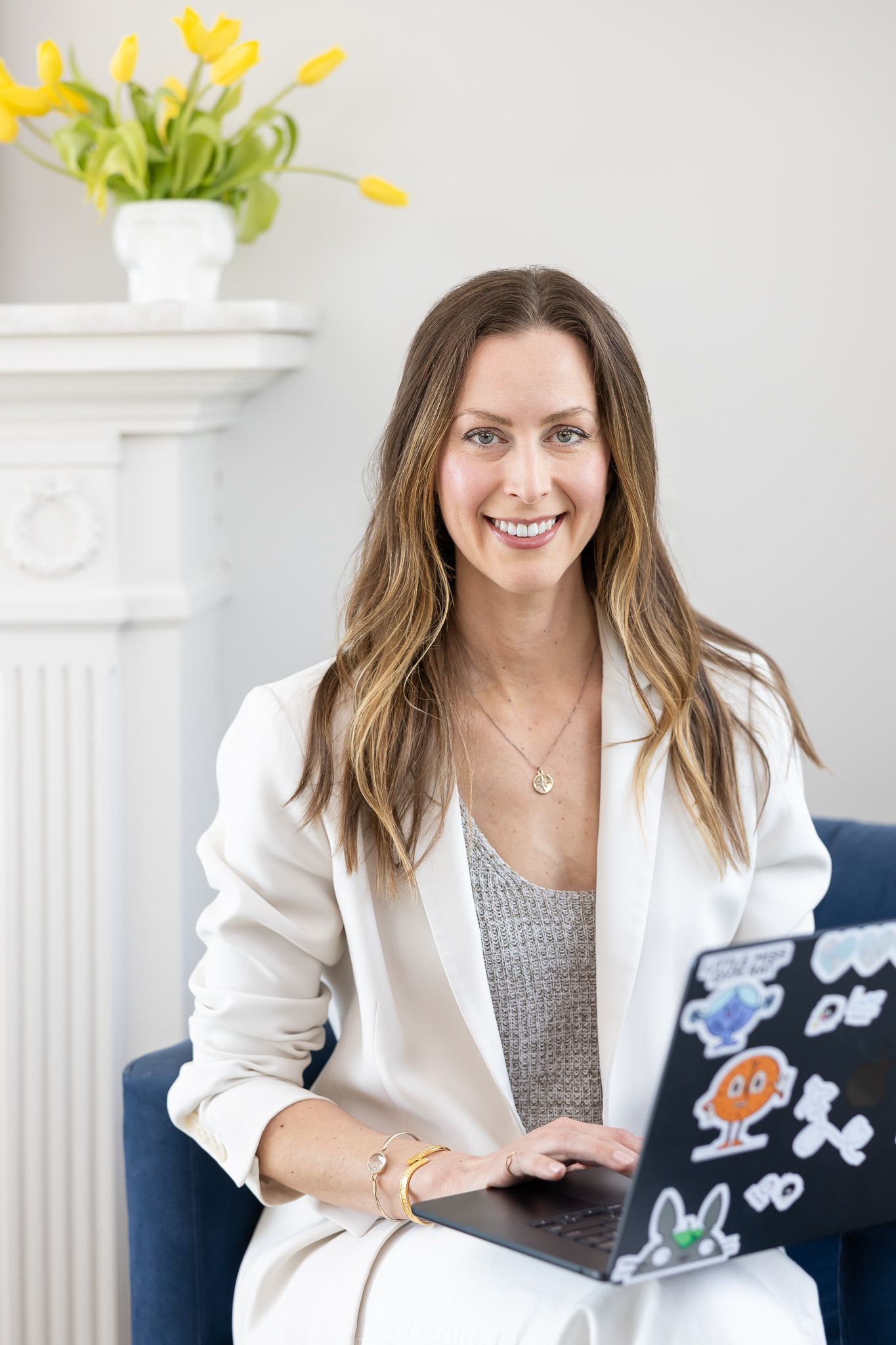 Jessica Stegner Seattle SEO consultant woman business owner lifestyle headshot sitting on chair with computer in lap in white suit