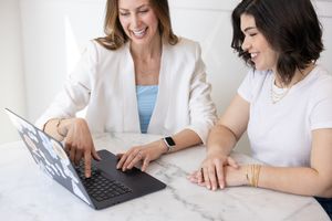 Jessica Stegner Seattle SEO consultant woman business owner branding 2 women sitting at table 1 pointing at laptop screen explaining to othe