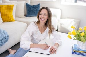 Jessica Stegner Seattle SEO consultant woman business owner branding sitting on floor at coffee table writing in journal looking away