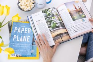 Jessica Stegner Seattle SEO consultant woman business owner branding overhead flipping through travel magazine with book, popcorn at table