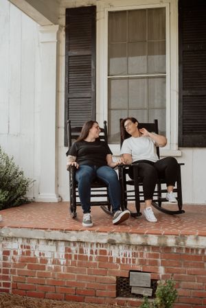 Relaxed lifestyle portraits on a brick porch with rocking chairs.