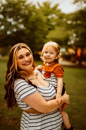 A heartwarming outdoor portrait showing matching striped shirts and joyful expressions.
