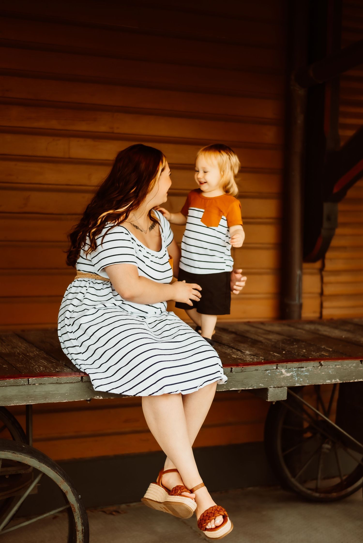 Matching striped outfits on porch in warm sunlight.