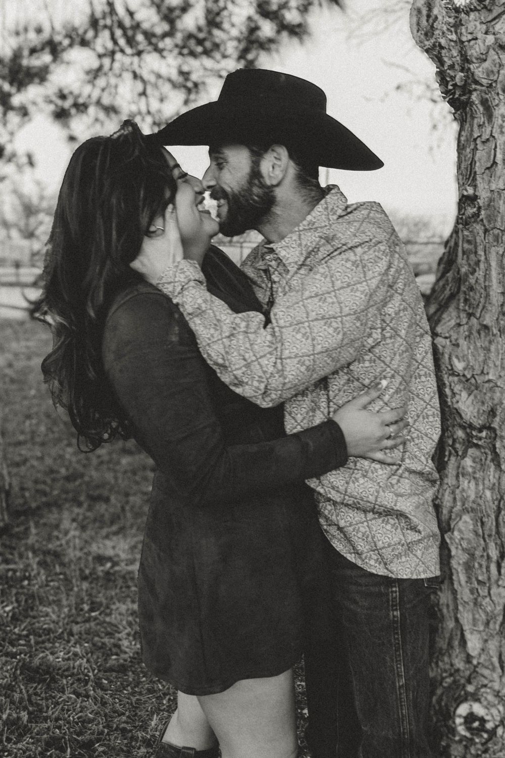 Black and white romantic portrait session near tree.