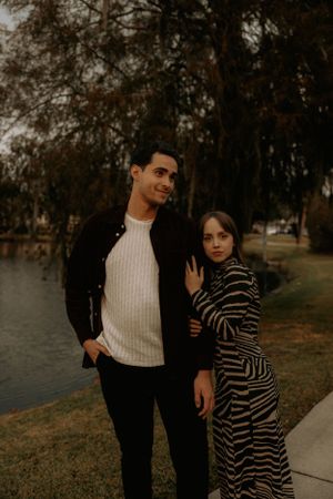 Two people share intimate moments during a lakeside photoshoot in fall.