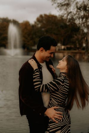 Intimate moment between a couple near a lake during golden hour.