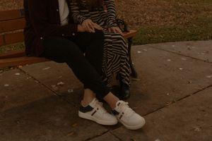 Two people sitting together on a bench in dim evening light.