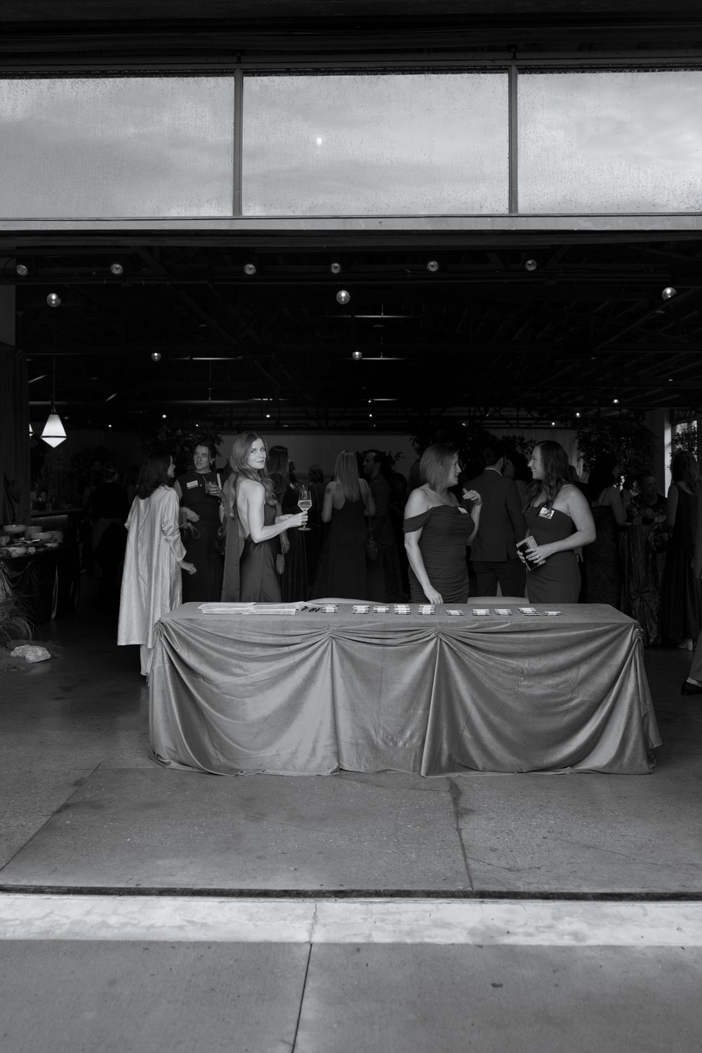 Four black and white images showing a row of white sheets hung as curtains across what appears to be a garage or storefront.