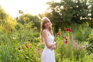 A lush garden setting with wildflowers and natural greenery captured in warm evening sunlight.
