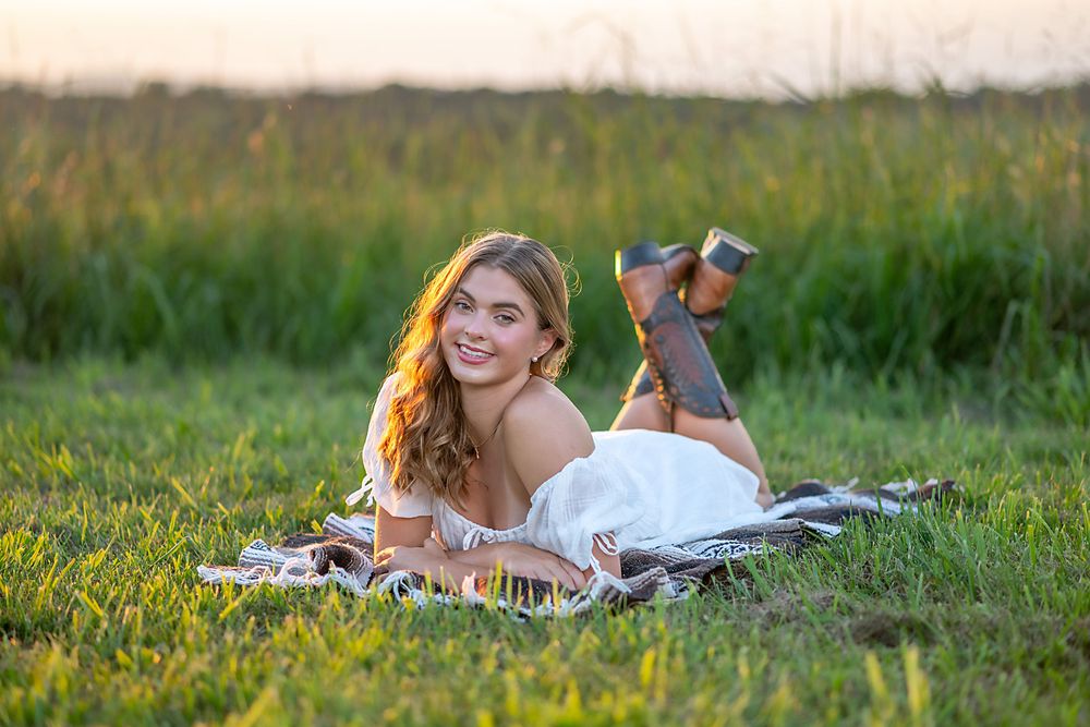 Relaxing on a picnic blanket in a sunlit grassy meadow during golden hour.