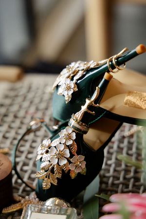 Decorative champagne bottles adorned with elegant silver floral designs rest on a textured surface.
