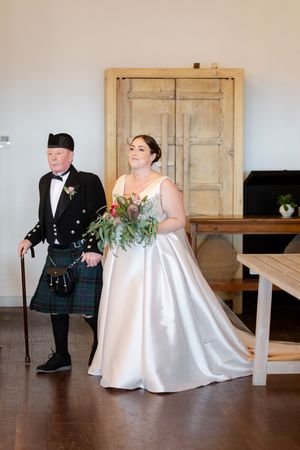 Sequence showing a couple in traditional wedding attire posing for photos in a rustic indoor setting with wooden doors.