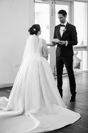 Stunning wedding dress with dramatic train photographed in sequence against wood floors.