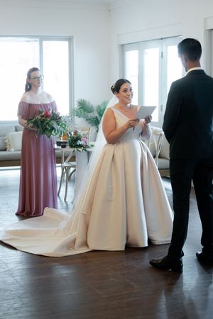 Wedding celebration in bright venue with flowing white gown and mauve bridesmaid dress.