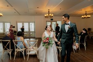 Newlyweds sharing a joyful moment while walking through their wedding reception venue.