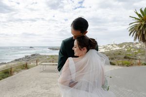 Romantic beachside wedding photography showing scenic coastal views with palm trees in the background.