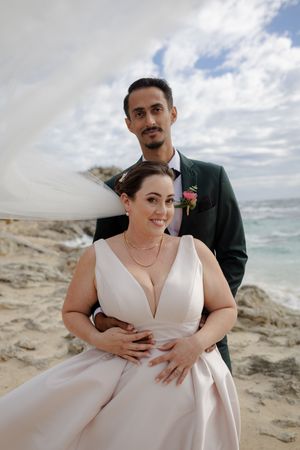 Wedding photos captured on a scenic coastal beach with dramatic cloudy skies and ocean views.