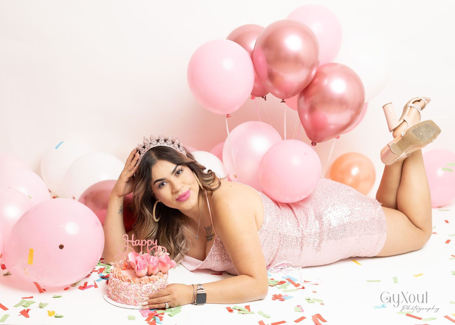 A celebration photo with silver number balloons 30 and a woman in a sparkly black cocktail dress against a dark backdrop.