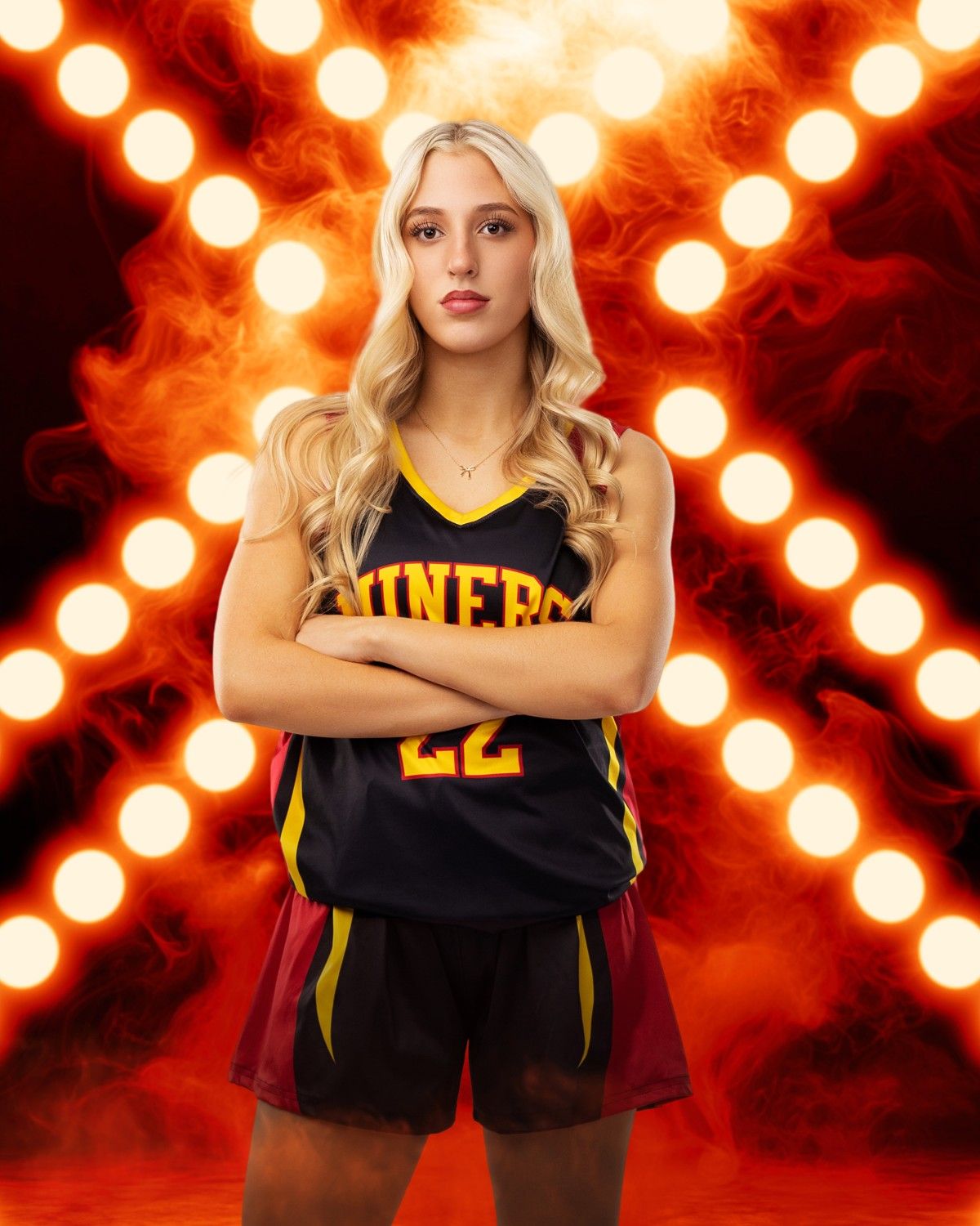 Basketball player poses against dramatic orange spotlit backdrop wearing black and yellow uniform.