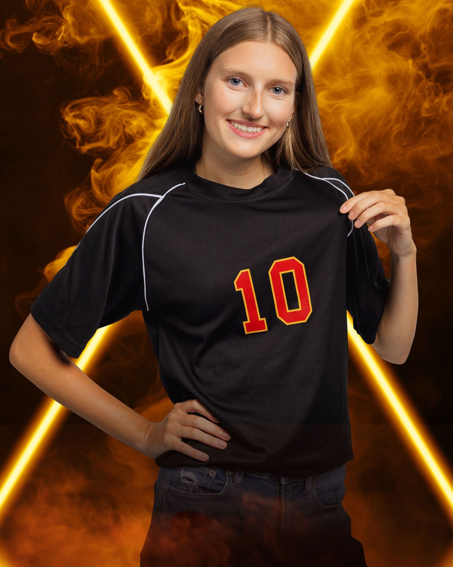 Student athlete holding black jersey with red number 10 against fiery background.