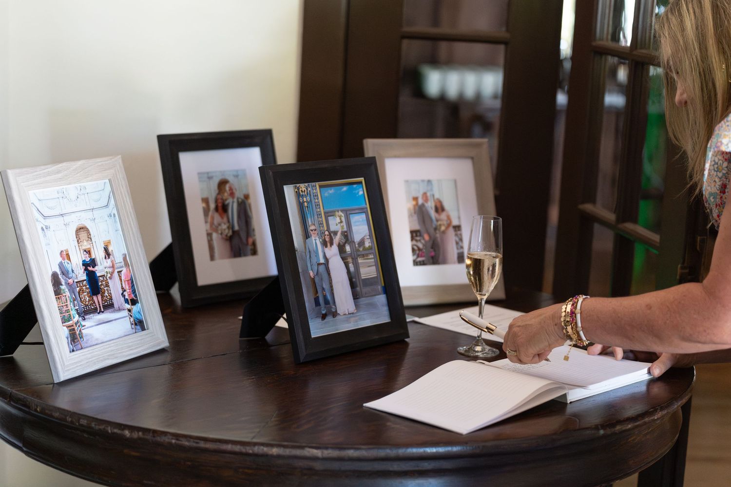 A collection of framed photographs displayed on a wooden shelf in a dimly lit room.