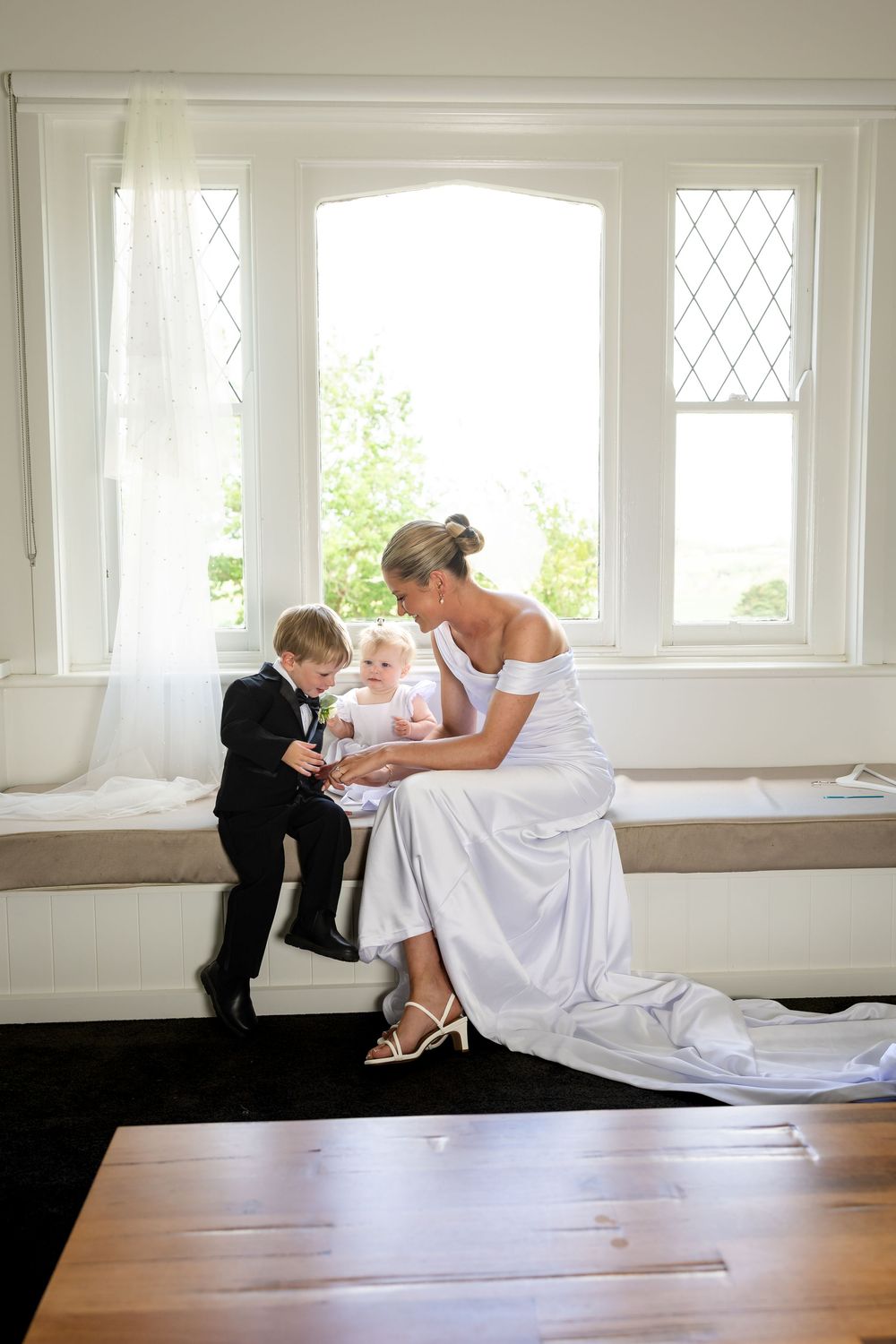 A series of artistic wedding photos showing a couple in black and white formal attire interacting on a hardwood floor.