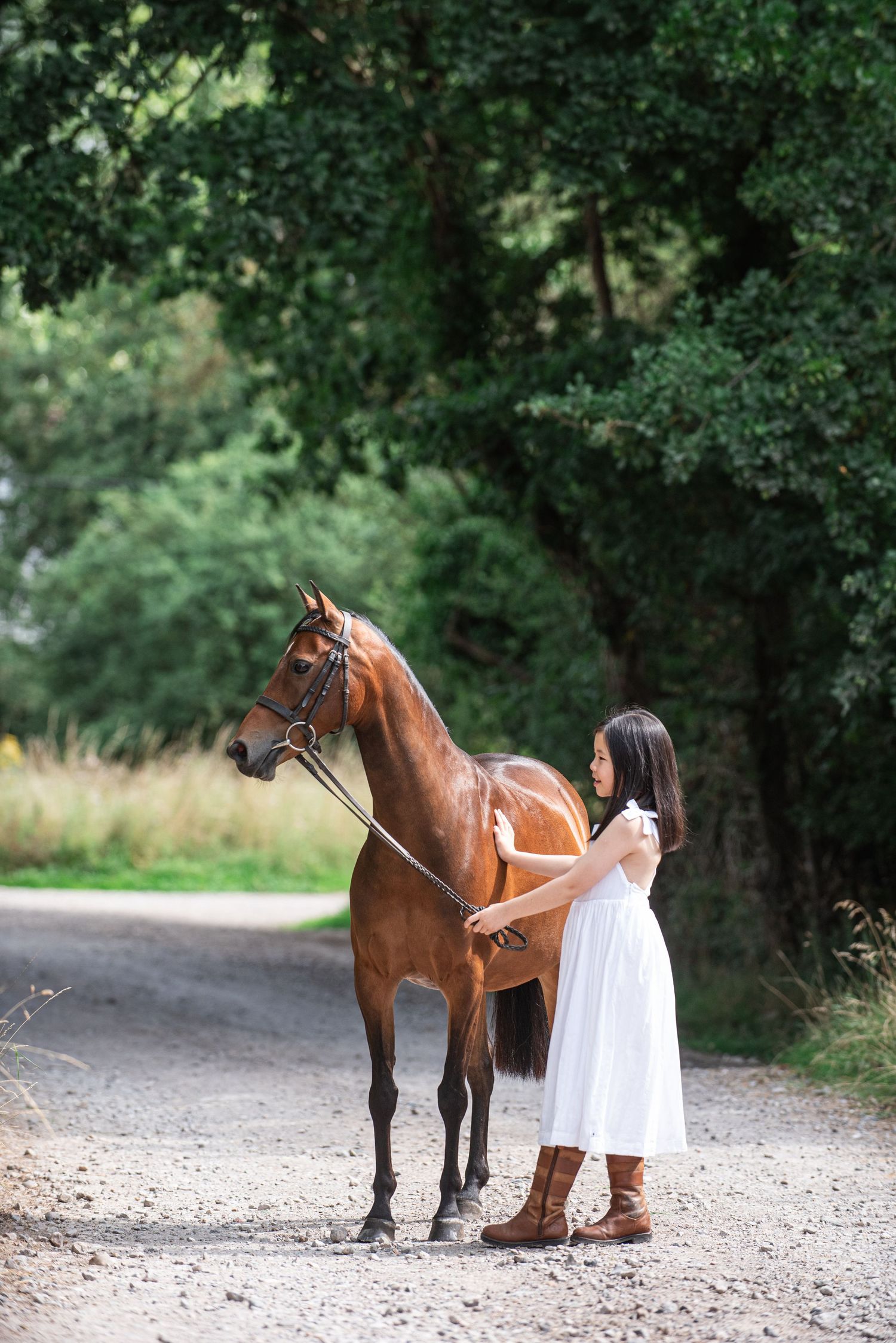 A quiet moment for Olivia Mu with her bay show pony, Dolly wearing a white dress and todpur country boots