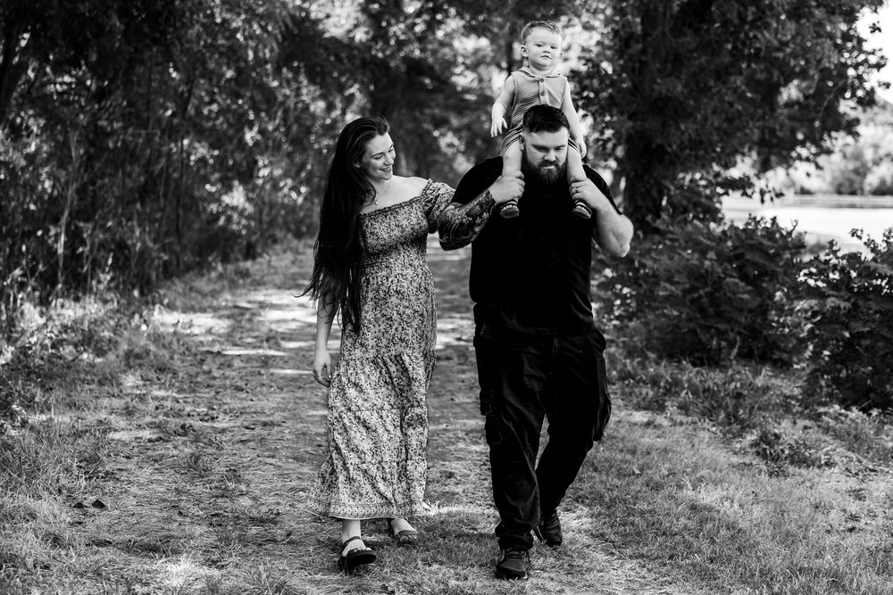 black and white photo of a family walking towards the camera during fort worth maternity photo session